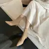 Look suave de estilo coreano con abrigo, botas cortas de gamuza de cuero nude empalmadas y ajustadas, invierno 2026, botines de tacón medio grueso con punta para mujer
