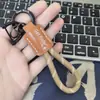 Colgante Llavero de Cuerda Exquisito Tejido a Mano con Logo Personalizado, Llavero de Cuero Genuino para Coche, Pequeño Regalo Universal al por Mayor