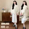 Nueva ropa de maternidad de otoño e invierno: un conjunto de dos piezas que presenta un cárdigan de punto con detalles trenzados y flecos, combinado con un vestido de punto que cubre el vientre y crea un efecto adelgazante