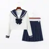 Conjunto de uniforme escolar estilo marinero japonés de alta calidad, moderno y popular, con cuello azul marino, diseño blanco de dos piezas, mangas largas y falda plisada en un estilo preppy y académico.