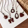 Cadena de suéter con lazo en forma de corazón de estampado de leopardo retro, un diseño único y elegante, con un collar largo geométrico de color café, creando un accesorio chic y atmosférico para mujer