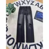 Calça jeans masculina rasgada, corte reto, modelagem solta, estilo American high street, lavada e com aspecto desgastado, azul vintage, que afina e valoriza o corpo, com cós elástico