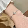Pulseira Branca de Madrepérola de Luxo Leve para Mulheres, Design de Nicho de Alto Padrão, Flor de Quatro Folhas, Zircônia em Forma de Coração, Joia de Mão Ajustável Venda por Atacado
