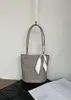 Bolsa de ombro tipo balde tecida em pele de carneiro, design de nicho 2026, estilo artístico e casual, bolsa de ombro em couro genuíno para mulheres