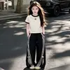 Traje de Verano para Niñas de Manga Corta 2026 Primavera y Verano Nuevo Estilo Conjunto de Dos Piezas para Niños con Letras y Rayas Lazo Pantalones de Pierna Ancha