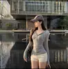 Camiseta com capuz e decote V de manga longa para mulheres, novo estilo outono 2026, corte justo, acinturada, com botão na camada interna