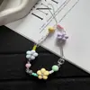 Diseño nuevo y único con cuentas florales tachonadas de diamantes, una correa para teléfono linda y versátil, y un dije de cámara CCD.