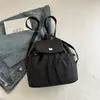 Mochila de moda con cordón de gran capacidad 2026 verano nueva bolsa versátil casual simple de lona a cuadros mochila escolar