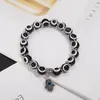 Colgante de aleación transfronterizo con palma hueca y ojos azules, pulsera elástica, joyería simple para parejas, venta directa de fábrica