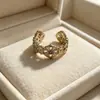 Anillo retro floral en tono café dorado, una pieza lujosa y única con un aire de alta gama, diseñado para apilar, con un borde de encaje, y perfecto para el dedo índice, ofreciendo un estilo moderno e individual