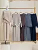 Conjunto de punto de estilo elegante y relajado, nueva colección otoño/invierno 2026, suéter de punto de cuello redondo liso y pantalones de pierna ancha, conjunto de dos piezas para mujer