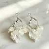 Pendientes de clip para oreja sin perforación con borla de pétalo de concha francesa súper etéreos para mujer, pendientes de botón de zirconia de alta gama elegantes y lujosos