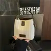 Bolso de paja tipo cubo nuevo estilo vacación de verano en la playa 2026, con un fresco diseño de patchwork en colores contrastantes y una textura tejida simple, un bolso para mujer