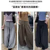 Calça pantalona cinza, estilo relaxado, minimalista, de corte amplo e afina a silhueta, perfeita para o início do outono, cintura alta, com detalhes de botões, perna larga e casual