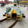 Grande Transportador Elétrico de Plataforma para Manuseio de Grandes Rolos de Papel em Oficinas, com Sistema de Correia de Corrente de Mesa para Integração na Linha de Produção e Carro sobre Trilhos Alimentado por Bateria