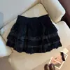 Foto real de la nueva colección otoño/invierno 2026: una falda corta de mujer acampanada con un diseño de patchwork de terciopelo y encaje, con cintura elástica