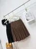 Foto real de la nueva falda midi de otoño 2026, estilo coreano chic, con botones, patchwork, plisada, de lunares, versátil y estiliza la figura.