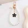 Elegante Cadena de Teléfono de Perlas y Flores, Pulsera de Perlas de Alta Gama para Mujer, Elegante Accesorio de Muñeca Estilo Chanel, Bestseller Internacional