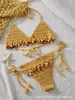 Conjunto de biquíni handmade de crochê com amarração no pescoço para mulheres, apresentando contas de madeira coloridas e franjas, perfeito para férias ou um passeio na praia