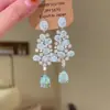 Brincos vintage em formato de leque com franjas longas de contas em forma de gota d'água, estilo corte, com strass brilhantes, oferecendo um toque de luxo leve e sofisticado.