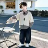 Conjunto de Camisa Falsa de Duas Peças para Meninos Primavera e Outono 2026 Outono Novo Conjunto de Moletom Infantil com Calça Jeans Curvada Tendência