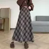 Foto real de falda de lana a cuadros estilo coreano de longitud media para otoño/invierno 2026, con un bajo amplio que cubre las caderas y estiliza.