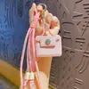 Serie de llaveros con funda tejida de cuero de dibujos animados para auriculares, colgante lindo para bolso, llavero para coche, pequeño regalo