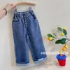 Pantalones vaqueros de primavera y otoño para niñas, elegantes y modernos para bebés y niños, estilo coreano con dobladillo remangado y detalles de etiqueta, diseño de pierna recta ancha a la moda
