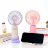 2026 Estilo Novo Simples Ventilador de Mão para Resfriamento ao Ar Livre Ventilador de Mesa para Estudante com Suporte para Celular Carregamento USB Ventilador Pequeno