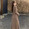 Nueva colección de principios de otoño: un vestido de manga larga a rayas de bloques de color, entallado y adelgazante, con una capa estilo chal, combinado con una falda larga que se ajusta a la figura - un conjunto de dos piezas