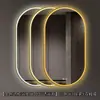 Espejo de baño inteligente ovalado en stock con lijado exterior e iluminación LED translúcida, adecuado para montaje en pared de baño y proyectos hoteleros, con opciones de personalización.