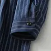 Foto real del nuevo vestido casual de otoño 2026 estilo japonés de longitud media con cuello de solapa, cintura de corbata, mangas largas y tela de algodón y lino a rayas