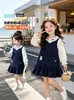 Vestido con Cuello de Muñeca Estilo Universitario para Niñas 2026 Otoño Nuevo Camisa de Manga Larga con Cuello de Muñeca para Niña Pequeña Vestido de Tirantes
