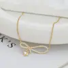 Chapado en oro real microincrustado con circonita cadena para clavícula de temperamento diseño de nicho femenino sentido de diseño collar con colgante de lazo gota de agua venta al por mayor