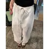 Pantalones blancos minimalistas ultrarrápidos de Tencel, estilo fino primavera-verano 2026 para personas petite, con pretina única en forma de capullo y piernas anchas.