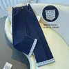 Jeans feminino de corte reto slim fit, nova coleção outono/inverno 2026, apresentando um design patchwork retrô americano com padrões xadrez e um corte solto de perna larga.