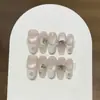 Um delicadoLua Suavesuave e etéreo pêssego leitoso rosa suave olho de gato francês microempilhado diamante aplicado à mão unha usável