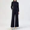 Conjunto plissado minimalista estilo japonês inspirado em Miyake, cor sólida com padrão sutil, top de manga longa com gola redonda, calça pantalona fluida, conjunto de duas peças casual para o outono