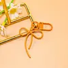 Llavero de lazo de cuentas estilo INS de colores con cinta, colgante de aleación, accesorio para niñas, charm para mochila, accesorio de hebilla para puerta