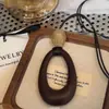 Estilo Harajuku ~ Collar con Colgante Ovalado Cortado en Cuerda de Cuero Negro para Mujer 2025 Nuevo Diseño de Nicho Cadena para Suéter Estilo Étnico