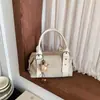 Bolsa de mão feminina estilo coreano com design de rebites de nicho, versátil e elegante para o outono, com estética de alta qualidade e alça de ombro, semelhante a uma bolsa almofada
