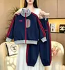 Conjunto de sudadera para niños 2026 otoño nuevo estilo universitario versión coreana casual holgado agradable a la piel bloques de color ropa deportiva al por mayor