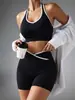Novo conjunto esportivo feminino de duas peças sem costura com gola halter e acabamento branco, incluindo um sutiã sem costas e shorts de ciclismo de cintura alta que levantam o bumbum