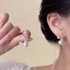 Un Pendiente de Lazo de Perlas Dos Vías Dulce y Elegante con un Diseño de Nicho y un Toque de Alta Gama, Presentado en un Estilo de Colgante Trasero