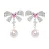 Únicos y elegantes, estos dulces pendientes de lazo con incrustaciones de diamantes y perlas exudan un aura elegante y sofisticada, ofreciendo un toque de lujo y versatilidad para cualquier atuendo.