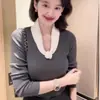 Atuendos de estilo coreano para otoño e invierno: un look relajado y sin esfuerzo con un suéter de punto, una capa interior de punto y un top blanco