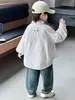 Camisa infantil fresca de rayas verticales de manga larga, colección primavera y otoño 2026, camisa de bebé de corte holgado, prenda exterior informal para niños