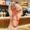 Nuevo Colgante de Cristal Super Brillante Acrílico Bolsa Auriculares Bluetooth Colgante Pequeño Llavero de Coche Cadena para Teléfono Móvil Venta al por Mayor