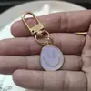 Llavero de cara sonriente de color aleación con goteo transfronterizo de comercio electrónico, accesorios de colgante para bolso con expresión irregular chapado en oro