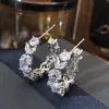 El fabricante Cao Shi suministra directamente pendientes de circón con forma de marquesa, pendientes creativos de aro en C con diseño floral, pendientes elegantes de lujo ligero para el día a día